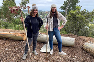Two women posing with rakes