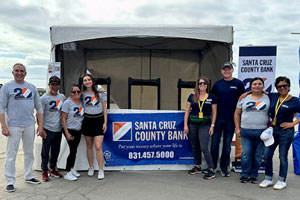 Bank employees posing with a Santa Cruz County Bank banner