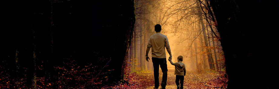Man and child walking in the woods